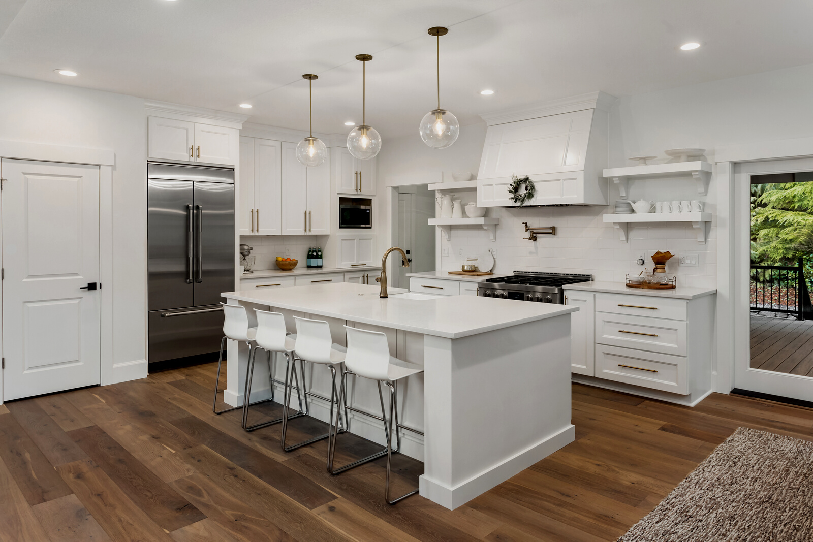 beautiful kitchen in new luxury home with island, pendant lights, and hardwood floors